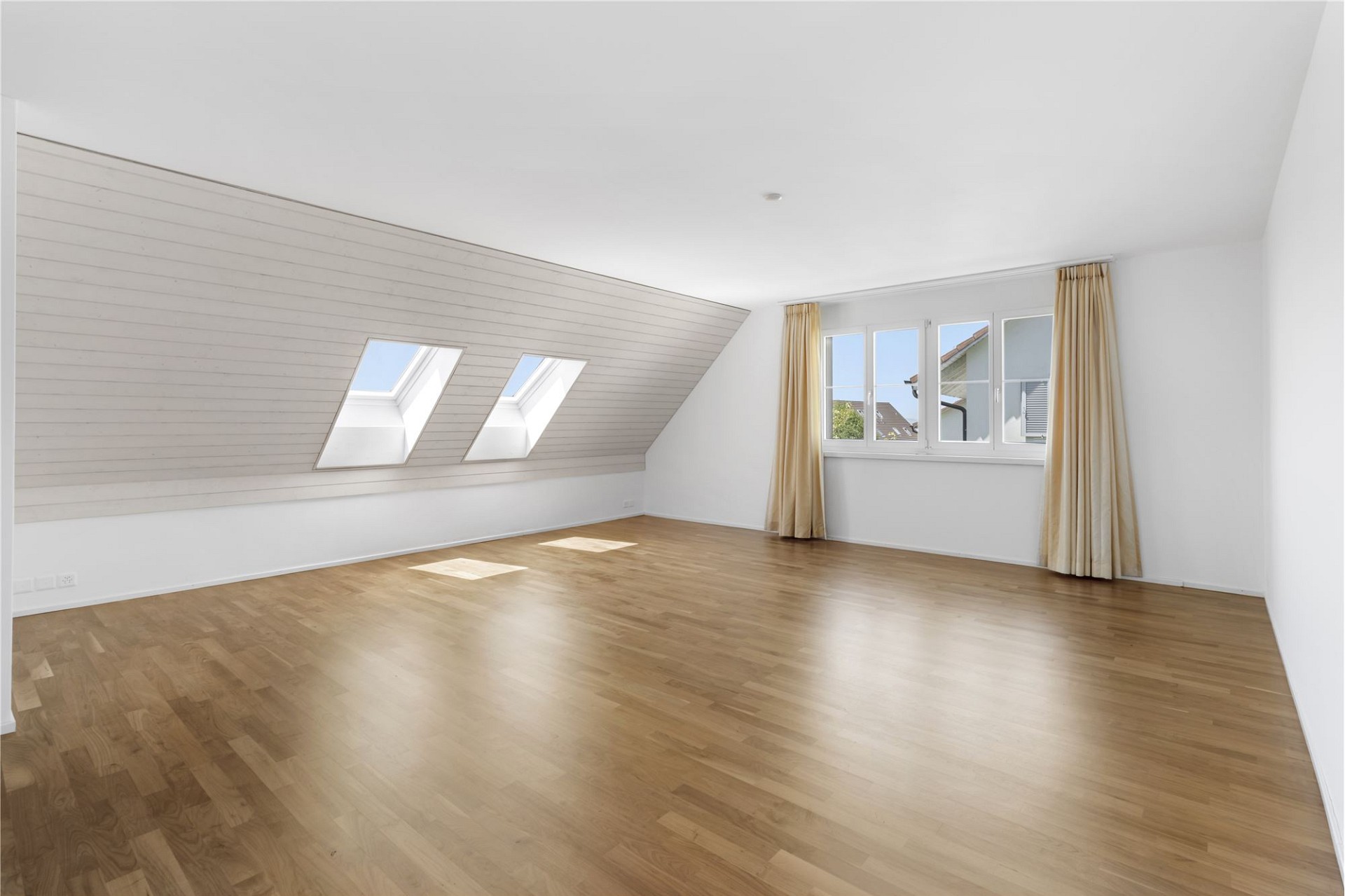 Helles Dachgeschosszimmer mit Holzparkett und Dachfenstern