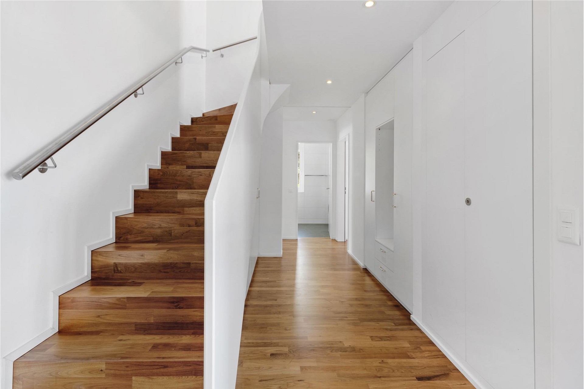 Heller Flur mit Treppe und Einbauschränken