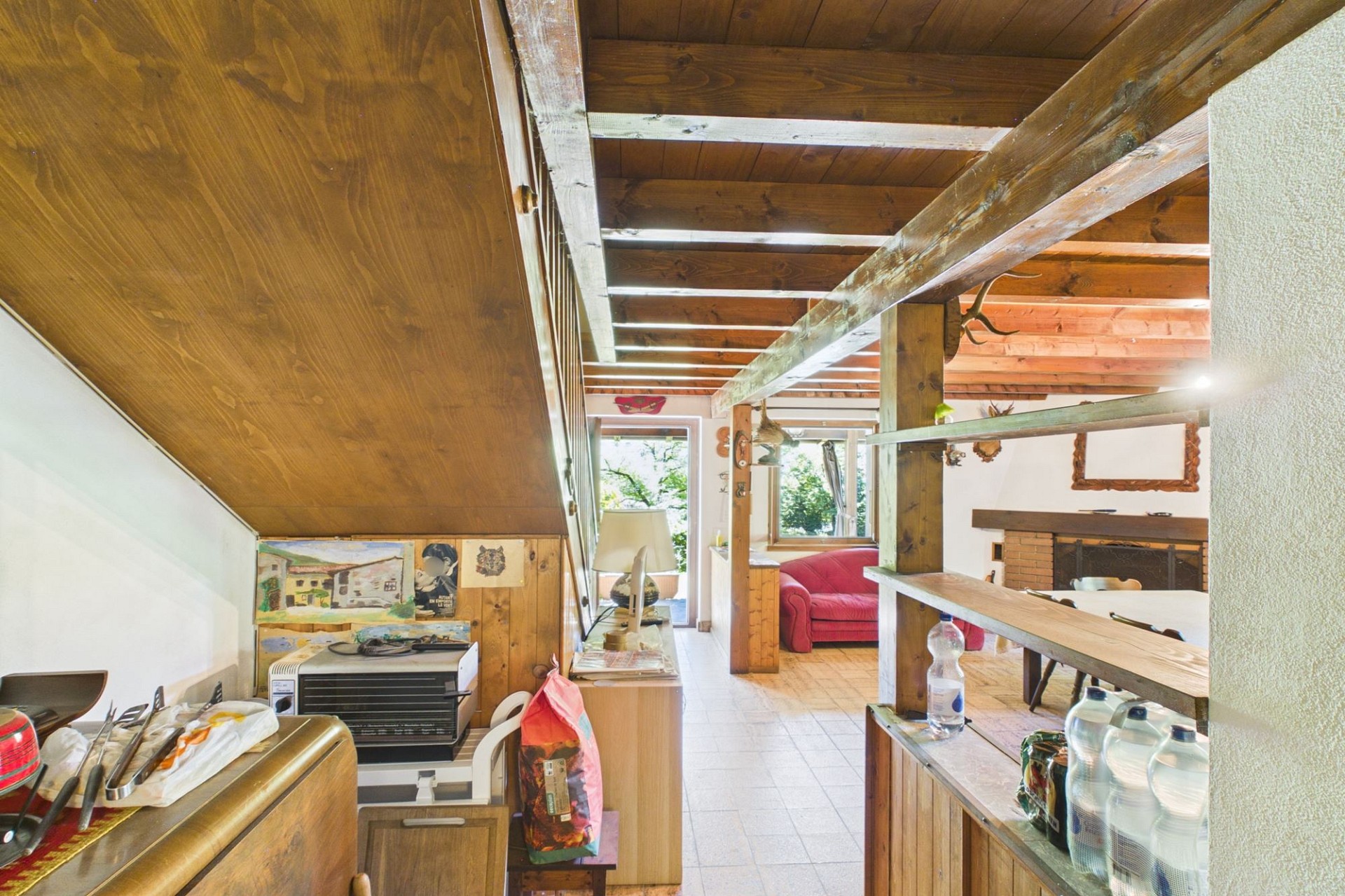 Gemütlicher Dachgeschoss-Wohnbereich mit rustikalem Kamin und Holzdecken