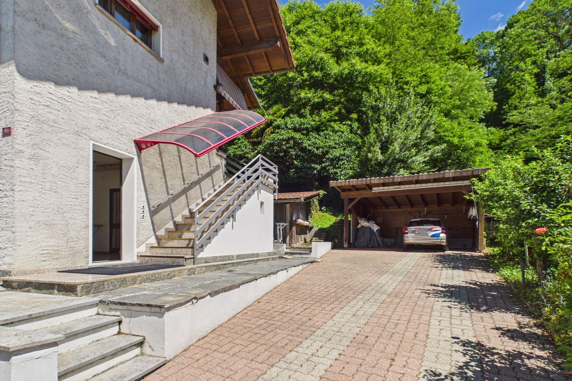 Außenansicht eines Hauses mit Auffahrt und Carport