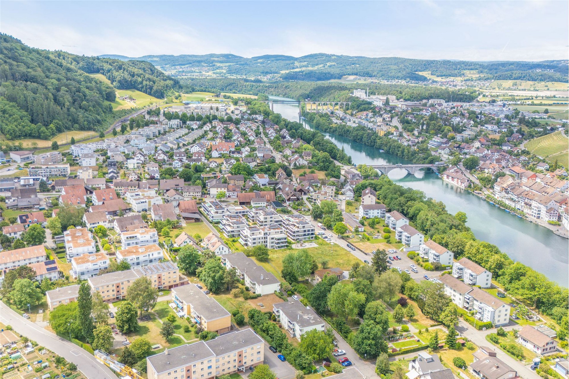 Luftaufnahme einer Flussstadt mit Wohngebieten