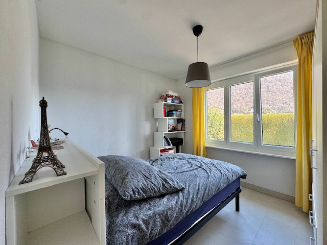 Schlafzimmer mit großem Fenster und gelben Vorhängen