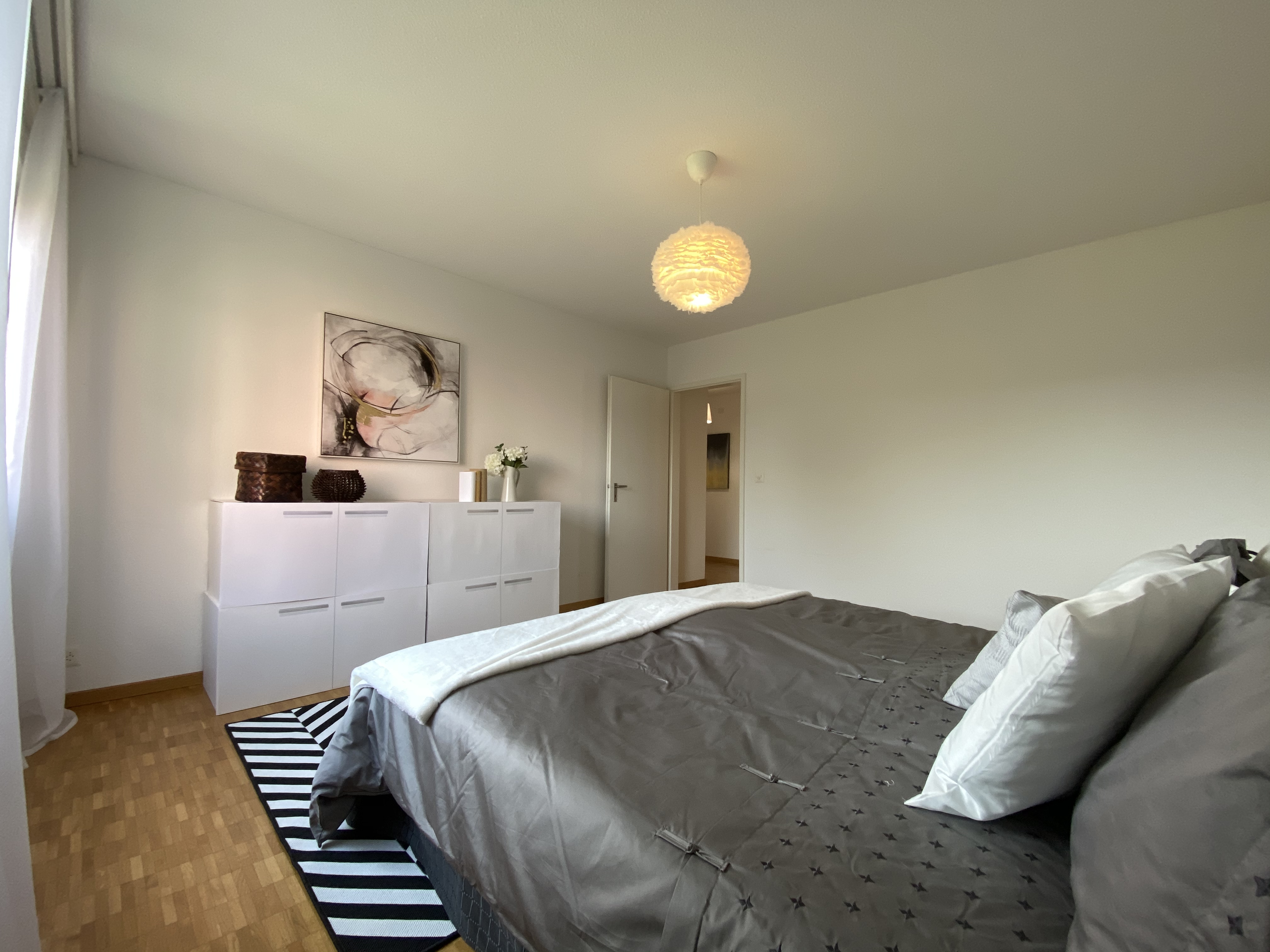 Schlafzimmer mit schlichtem, hellem Interieur