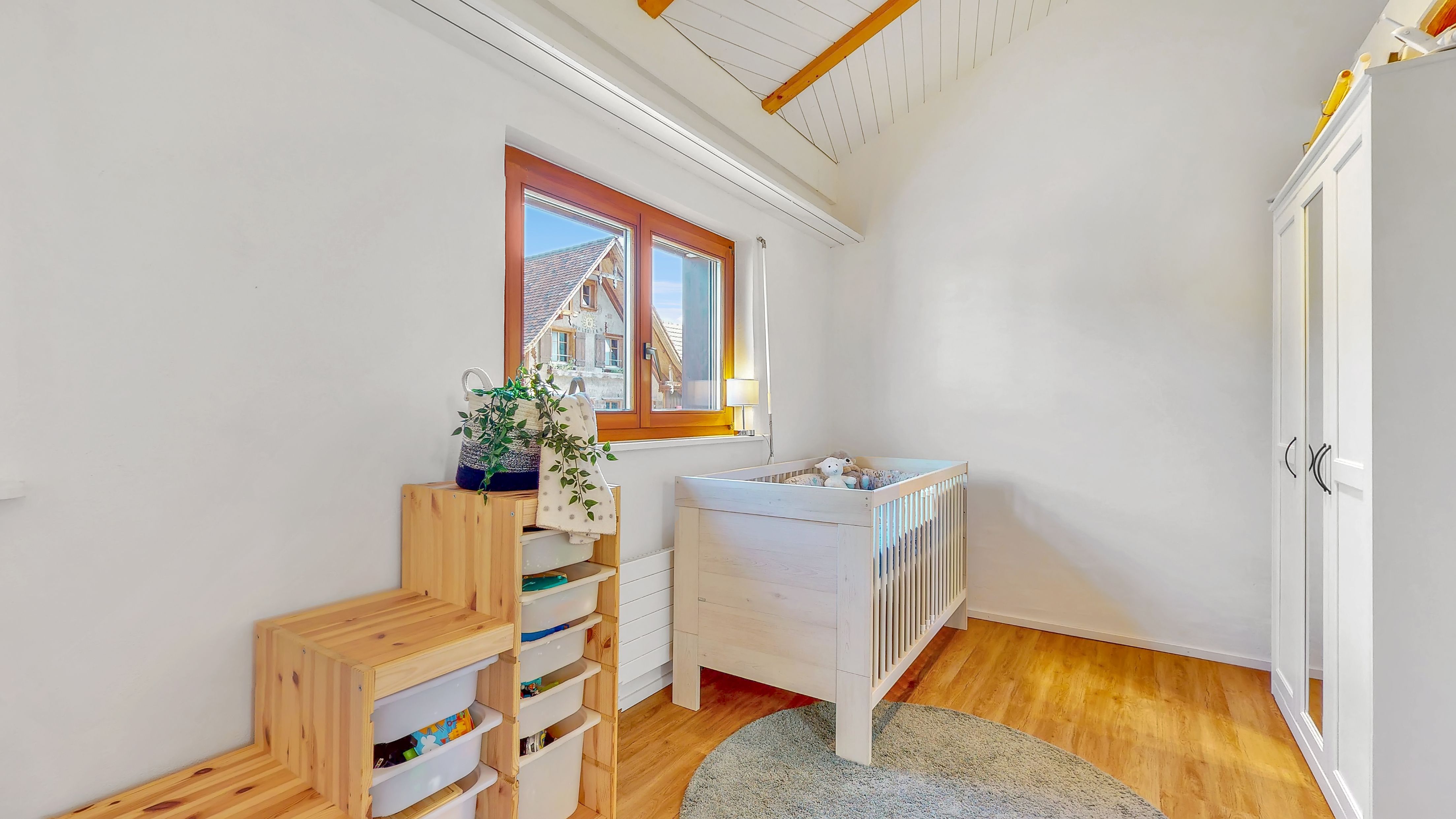 Kinderzimmer mit Dachschräge und Holzfenster