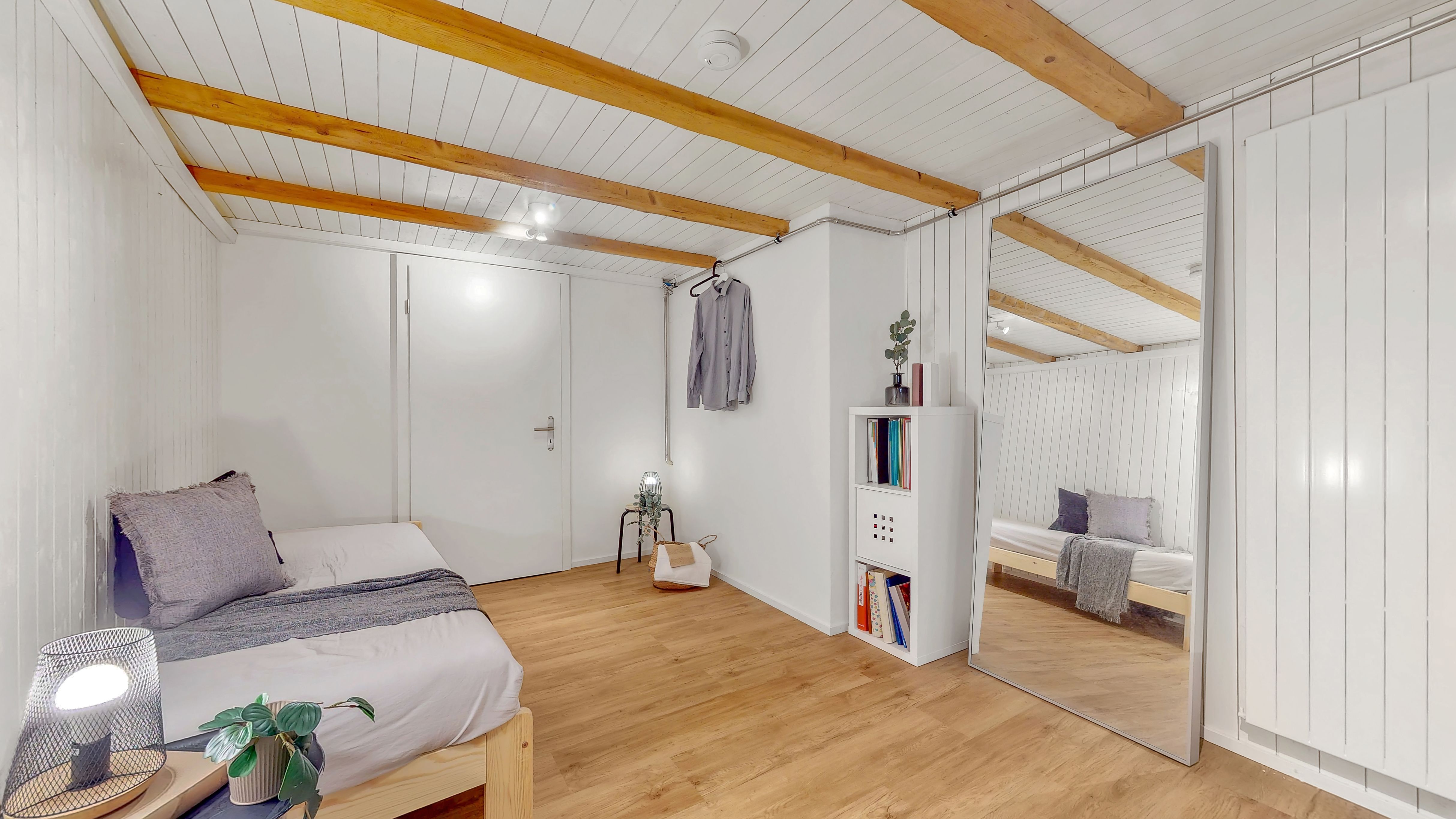 Helles Schlafzimmer mit sichtbaren Holzbalken