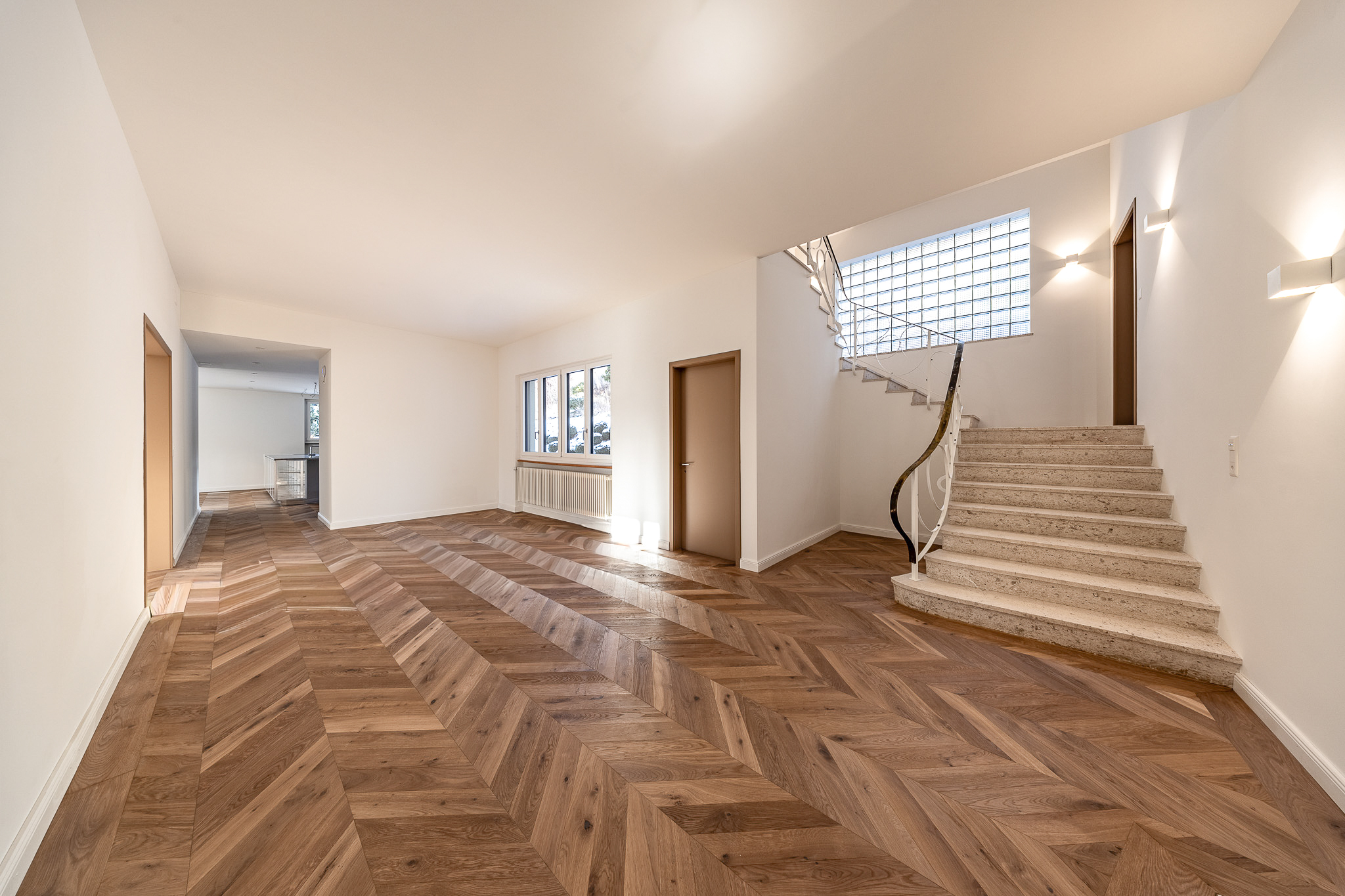 Heller Eingangsbereich mit Treppe und Fischgrätparkett