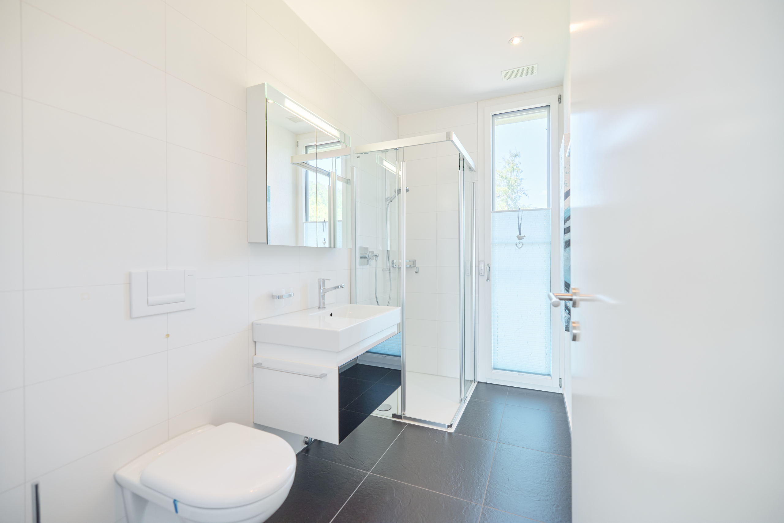 Modernes Badezimmer mit bodentiefer Dusche und Waschtisch
