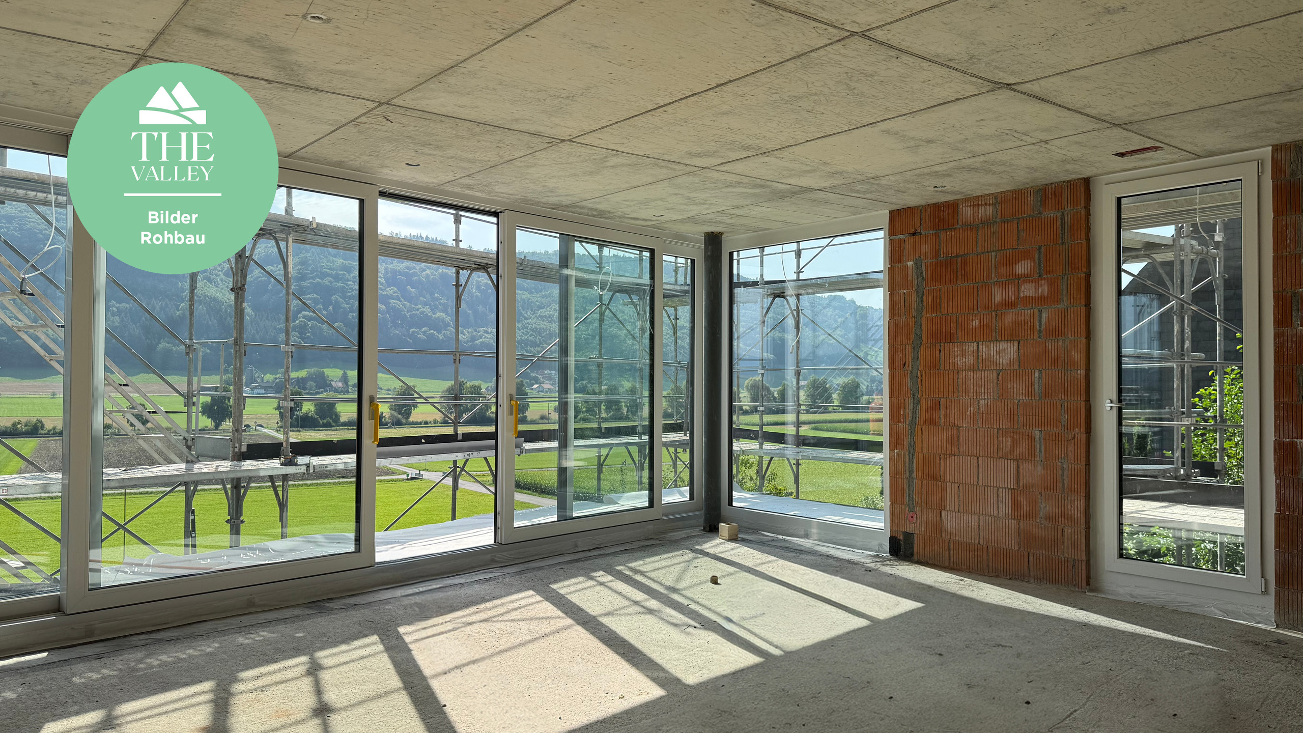 Rohbau mit Panoramafenstern und Bergblick