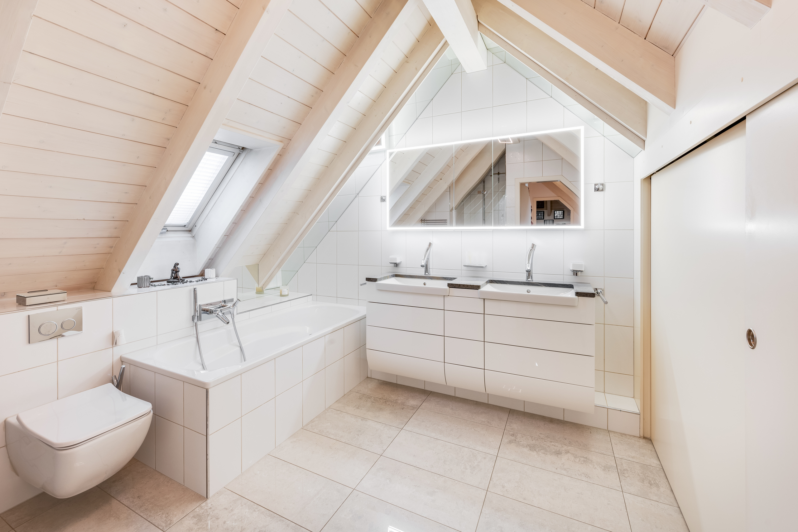 Helles Dachgeschoss-Badezimmer mit Badewanne und Doppelwaschtisch