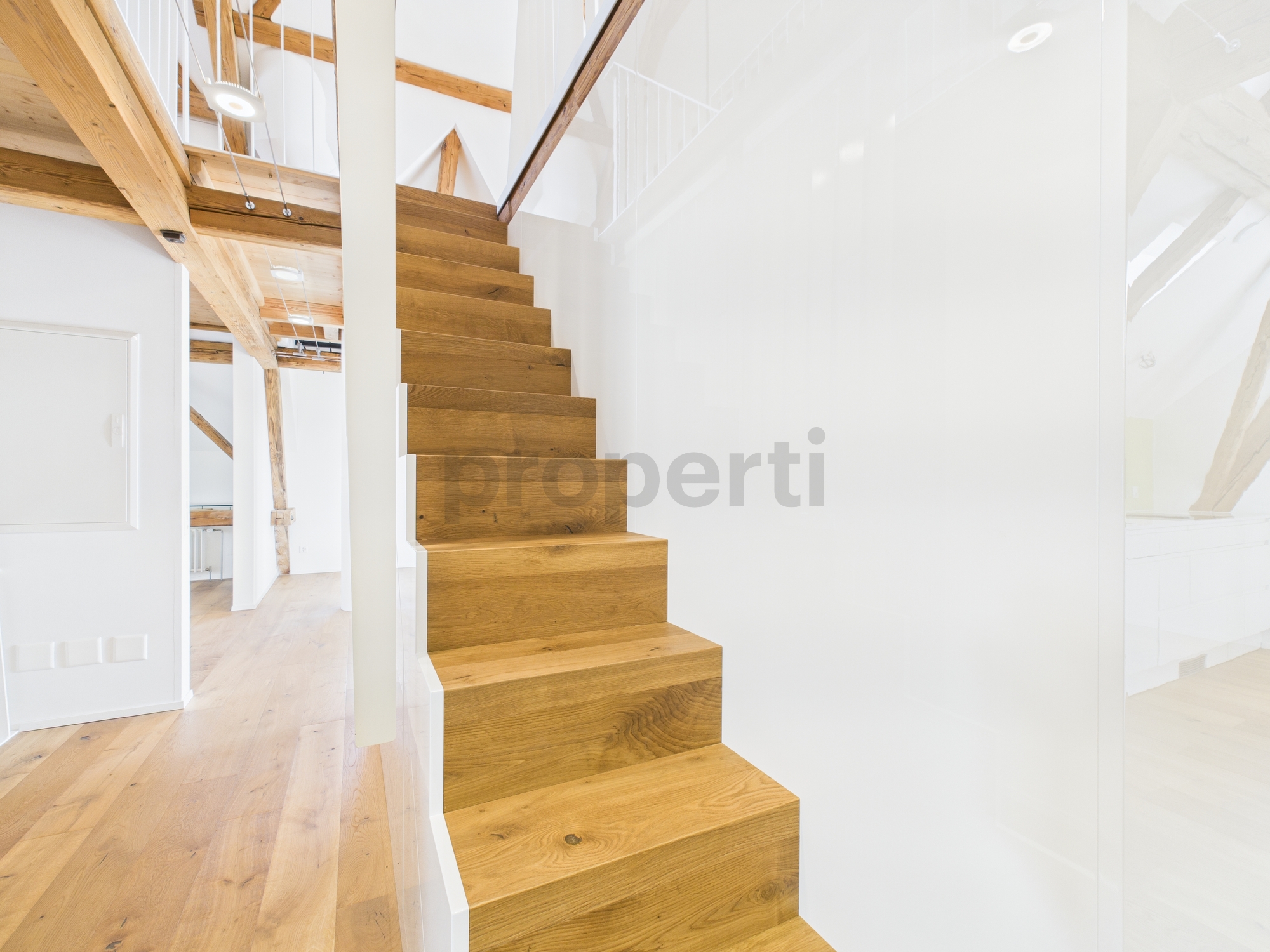 Offene Holztreppe in heller Galerie