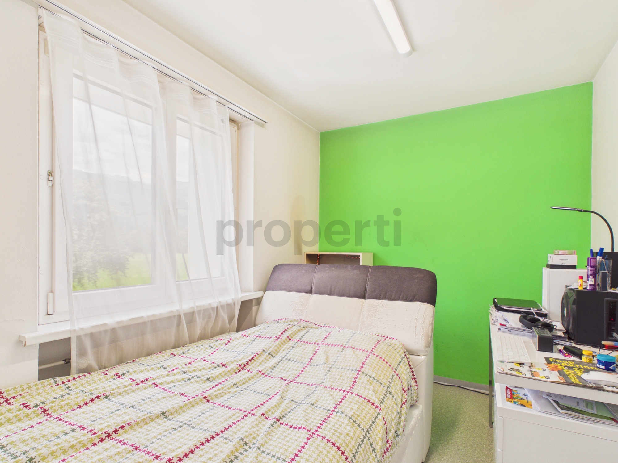 Schlafzimmer mit Fenster und grüner Akzentwand