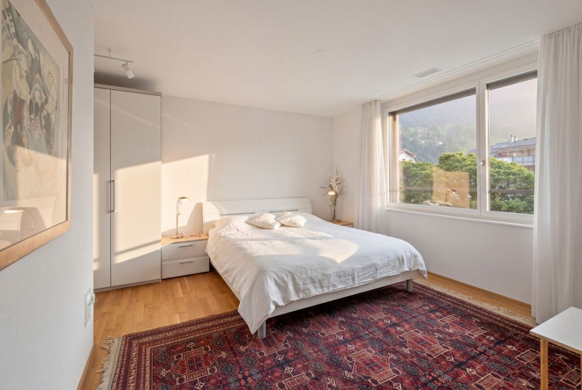 Helles Schlafzimmer mit großem Fenster und Teppich