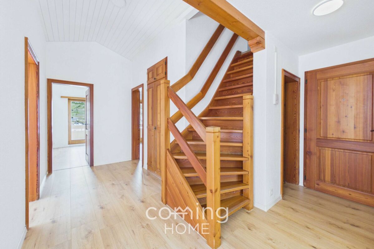 Heller Flur mit Holztreppe