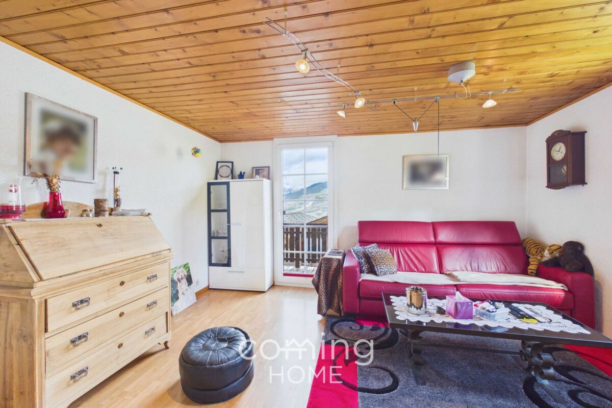 Wohnzimmer mit Holzdecke und Balkonblick