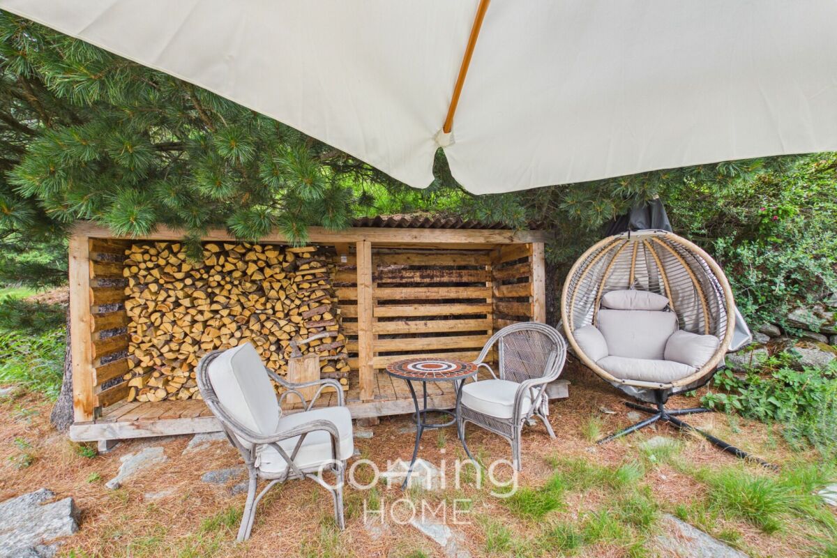 Außenlounge mit Brennholzlager und Hängesessel