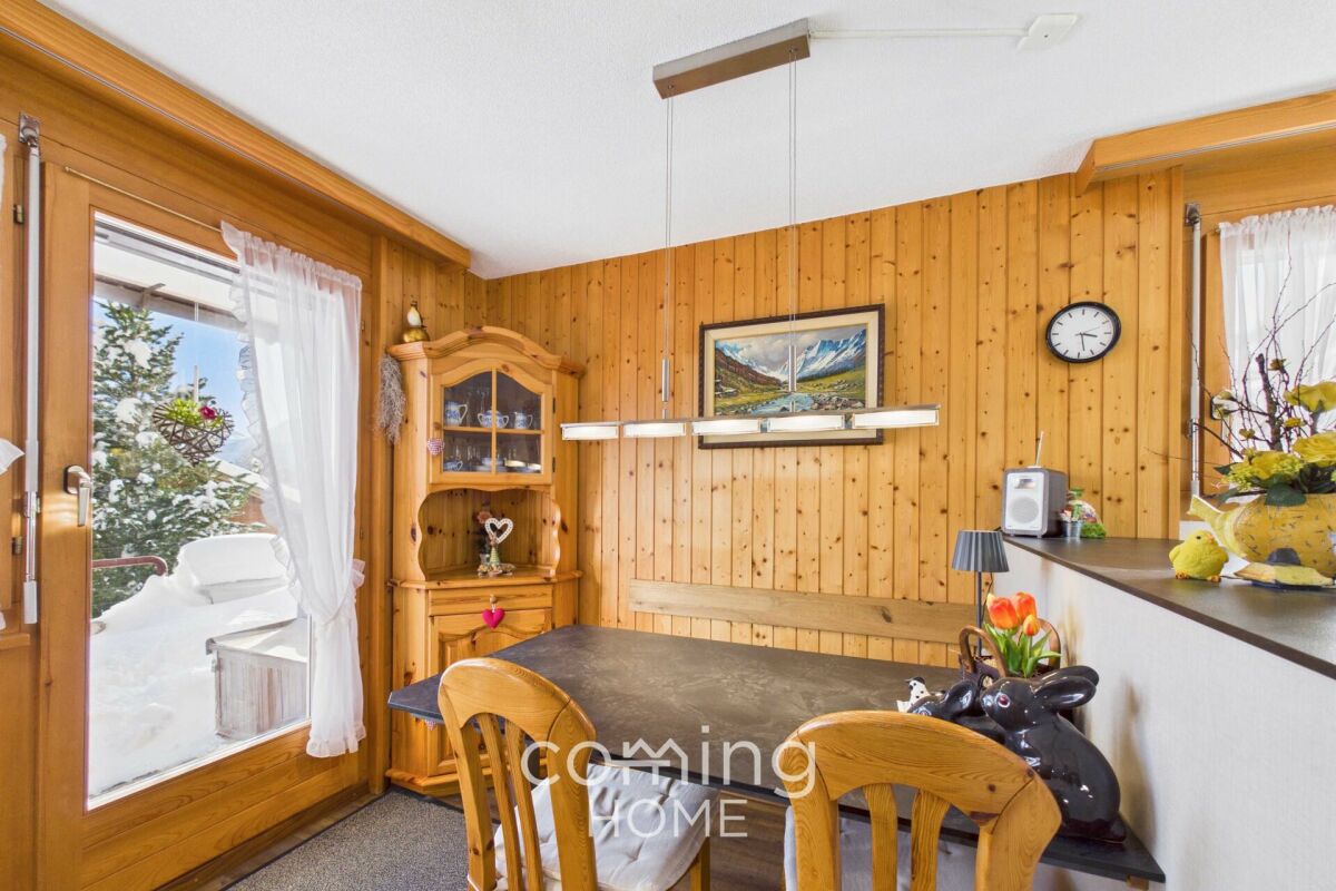 Gemütlicher Essbereich mit Holzvertäfelung und Balkonblick