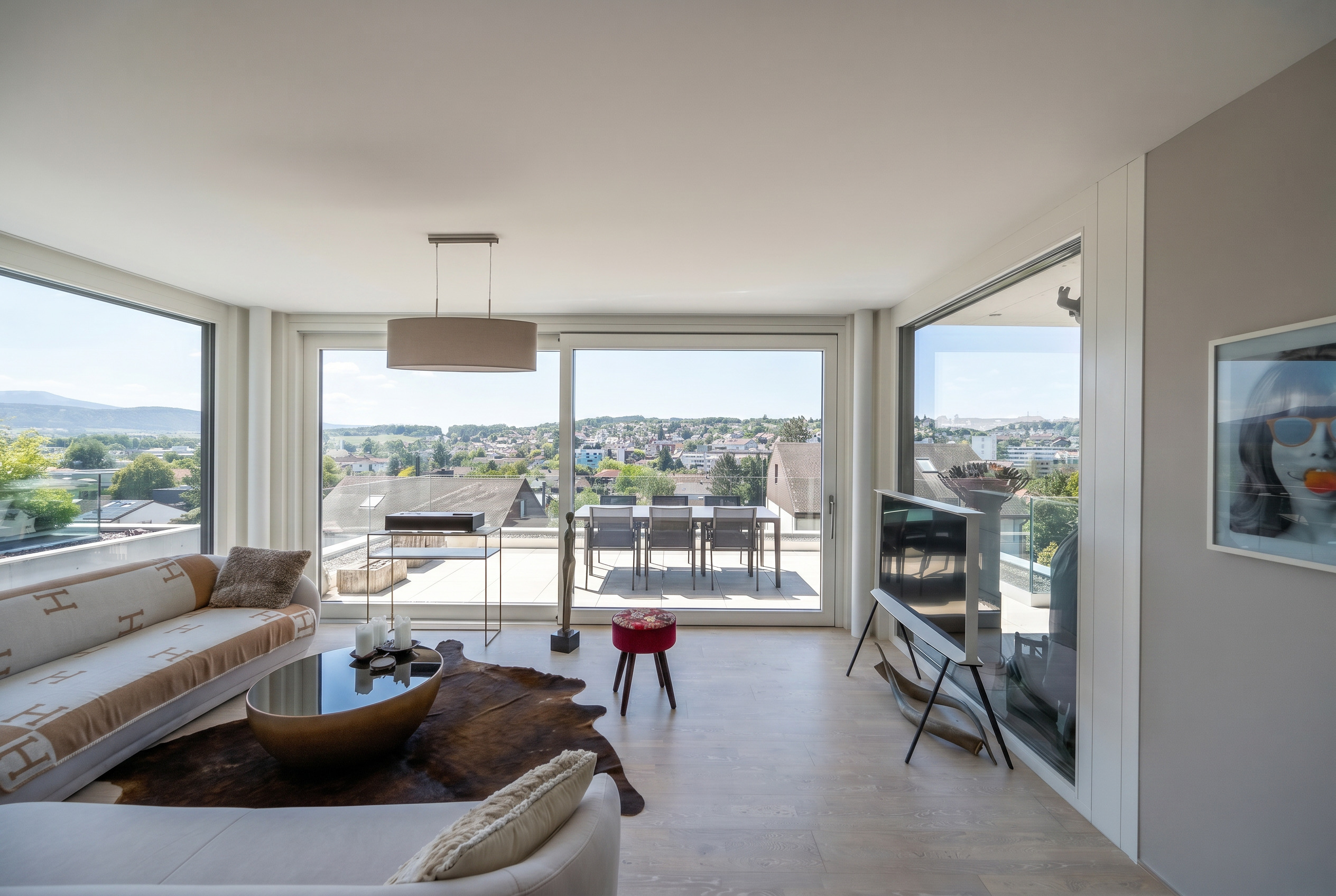 Helles Wohnzimmer mit Panoramafenstern und Dachterrasse