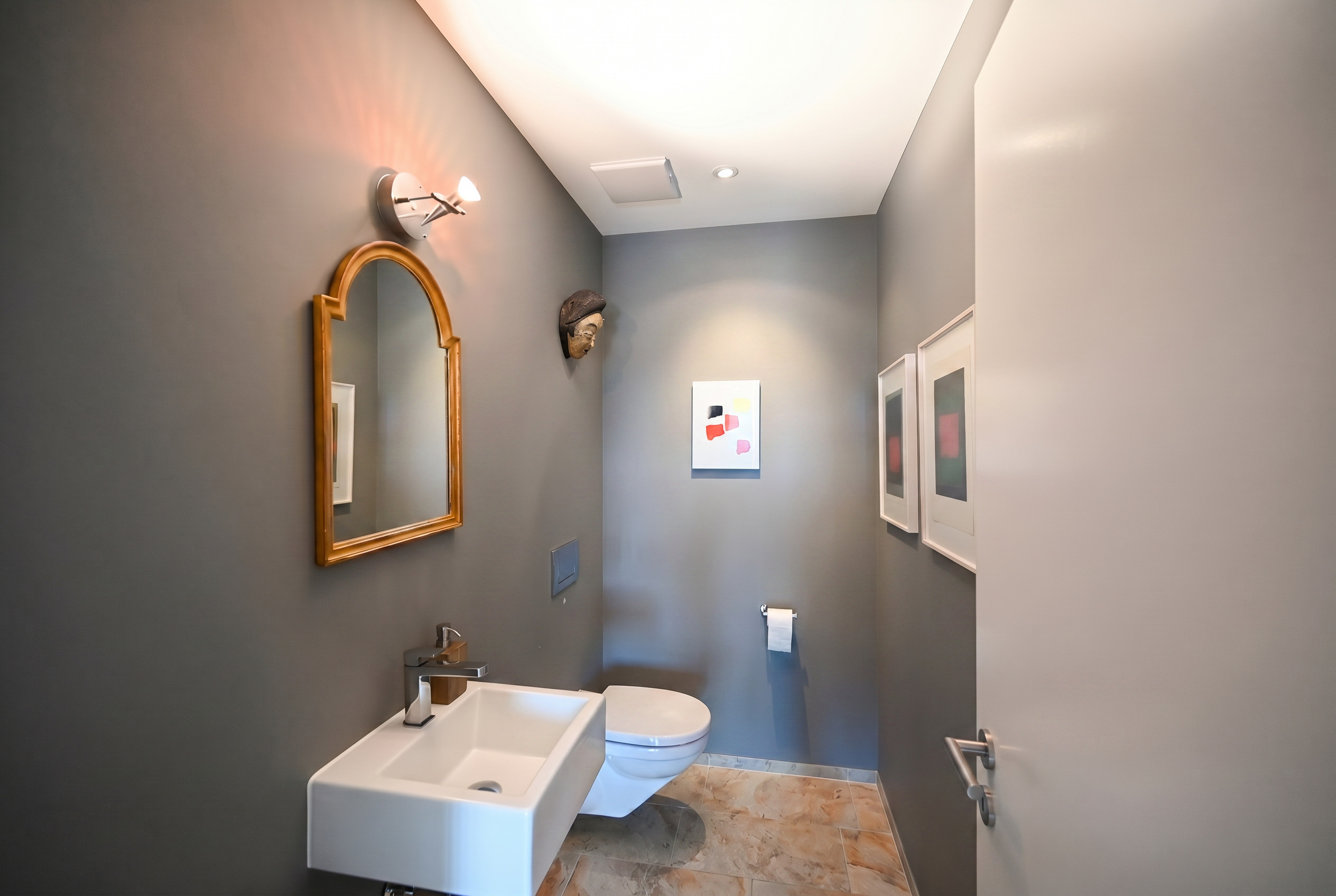 Gäste-WC mit grauen Wänden und Kunstakzenten