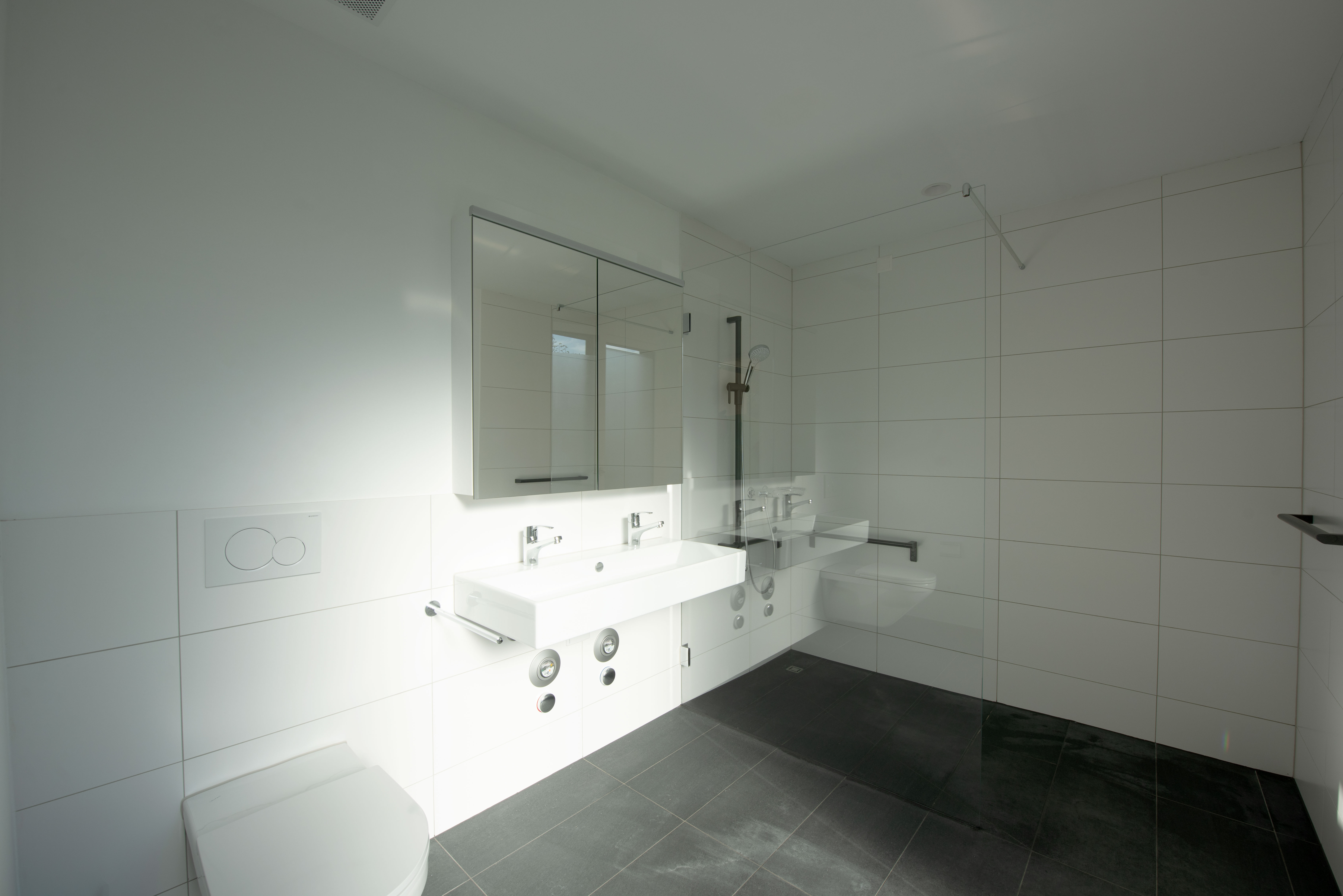 Modernes Badezimmer mit Glasdusche und Doppelwaschtisch