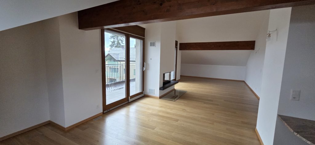 Heller Wohnraum mit Balkon und Sichtbalken