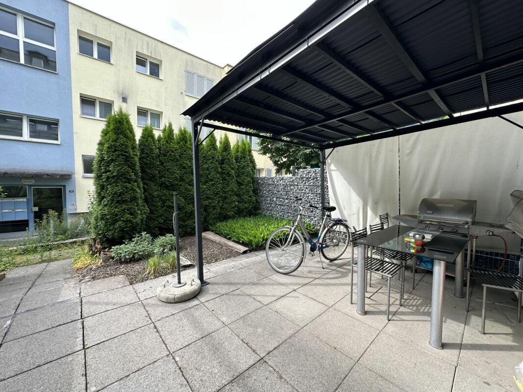 Außenbereich mit überdachtem Sitz- und Grillplatz