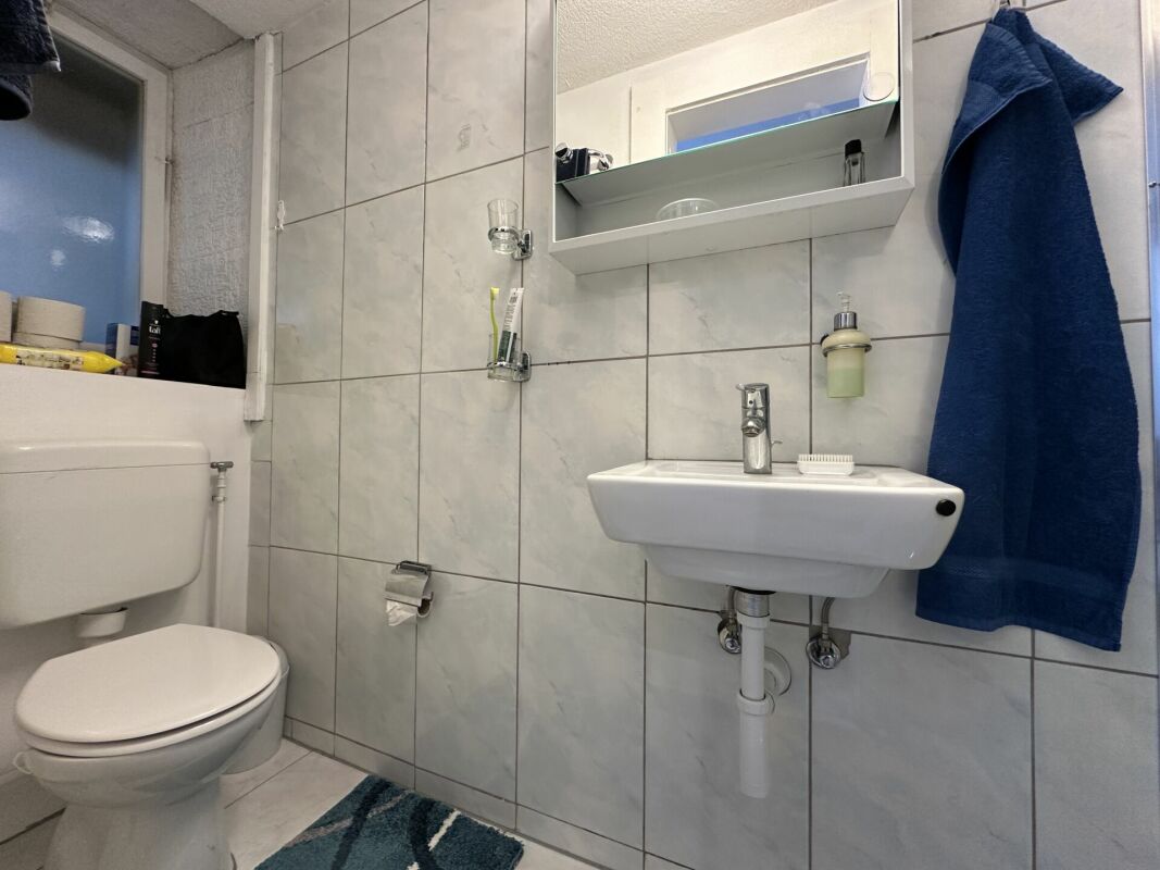 Kleines Badezimmer mit Wand-WC und Waschtisch