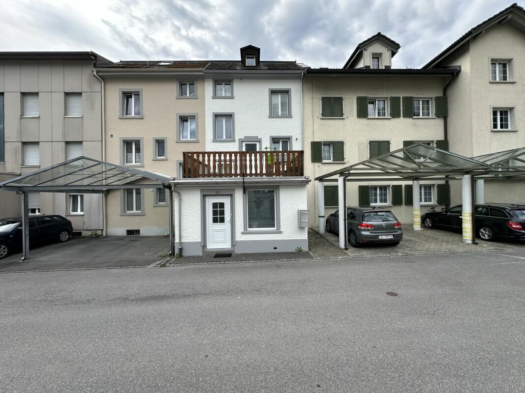Straßenansicht eines Wohngebäudes mit Carports