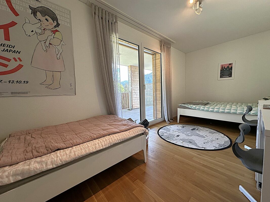 Helles Schlafzimmer mit zwei Einzelbetten und Balkonzugang