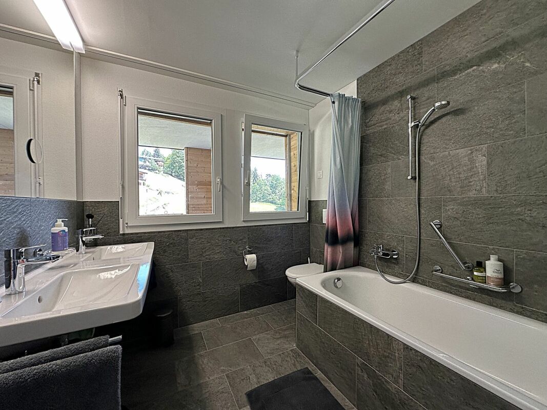Modernes Badezimmer mit Badewanne und Fensterblick
