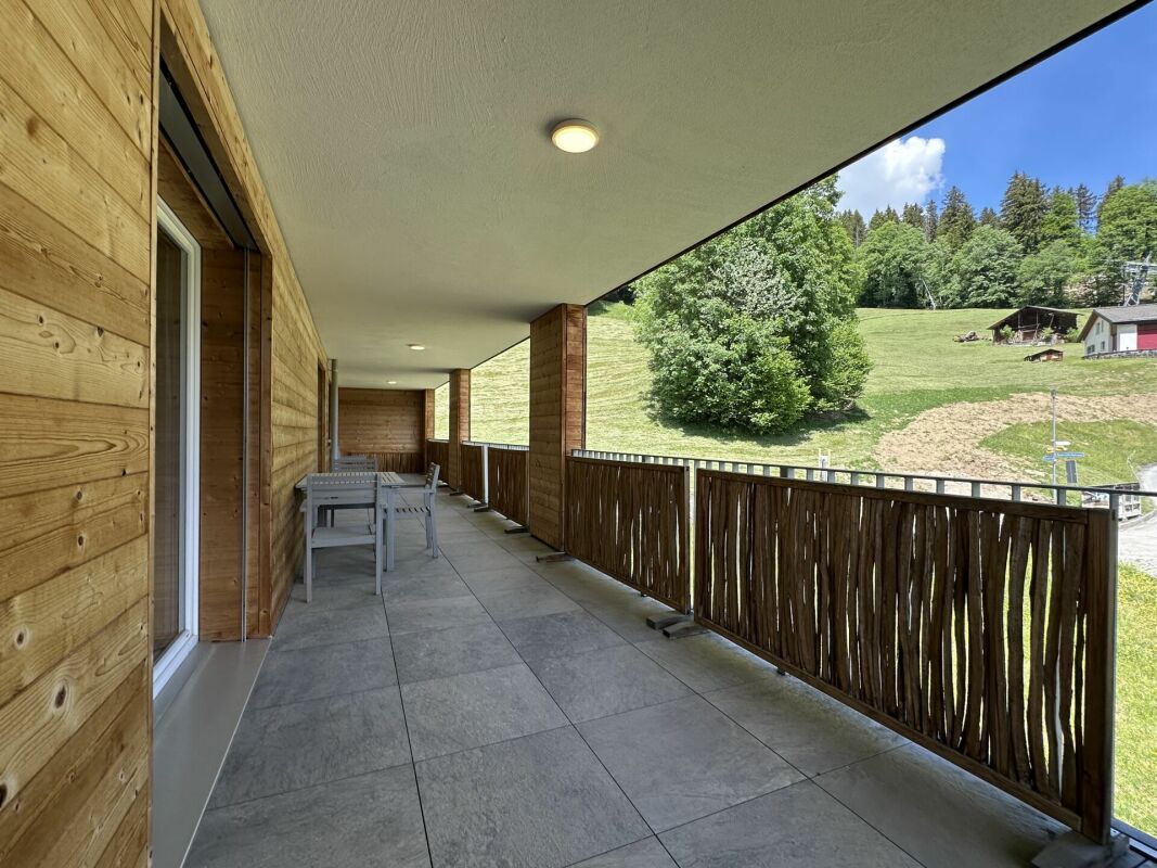 Überdachter Balkon mit Holzfassade und Bergblick
