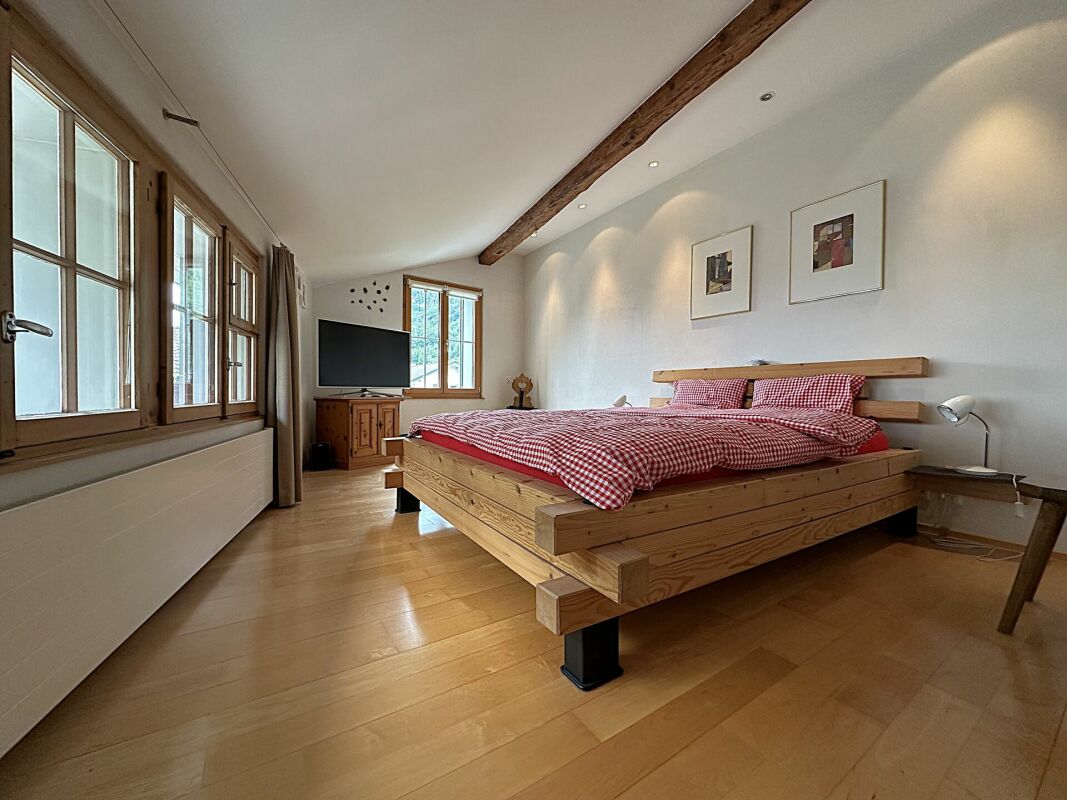 Schlafzimmer mit Holzbett und Sichtbalken