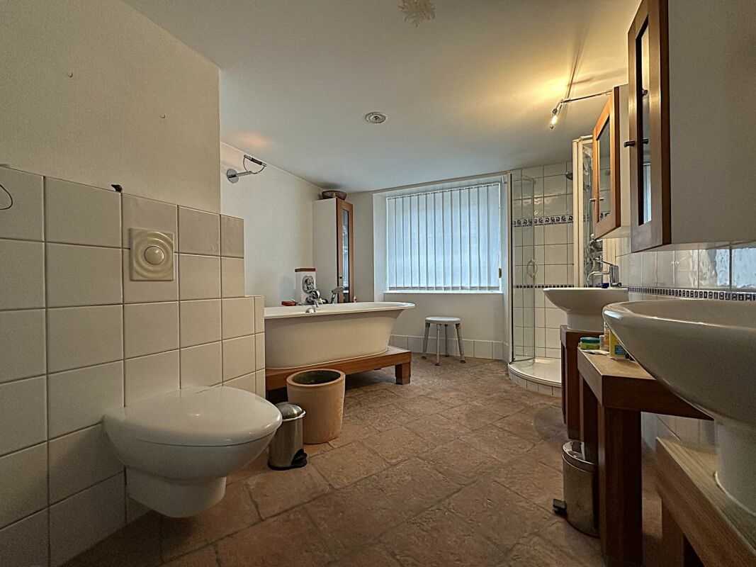 Helles Badezimmer mit Wanne, Dusche und Doppelwaschbecken