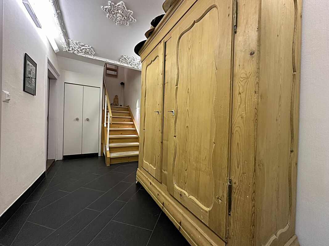 Flur mit Treppe und großem Holzschrank