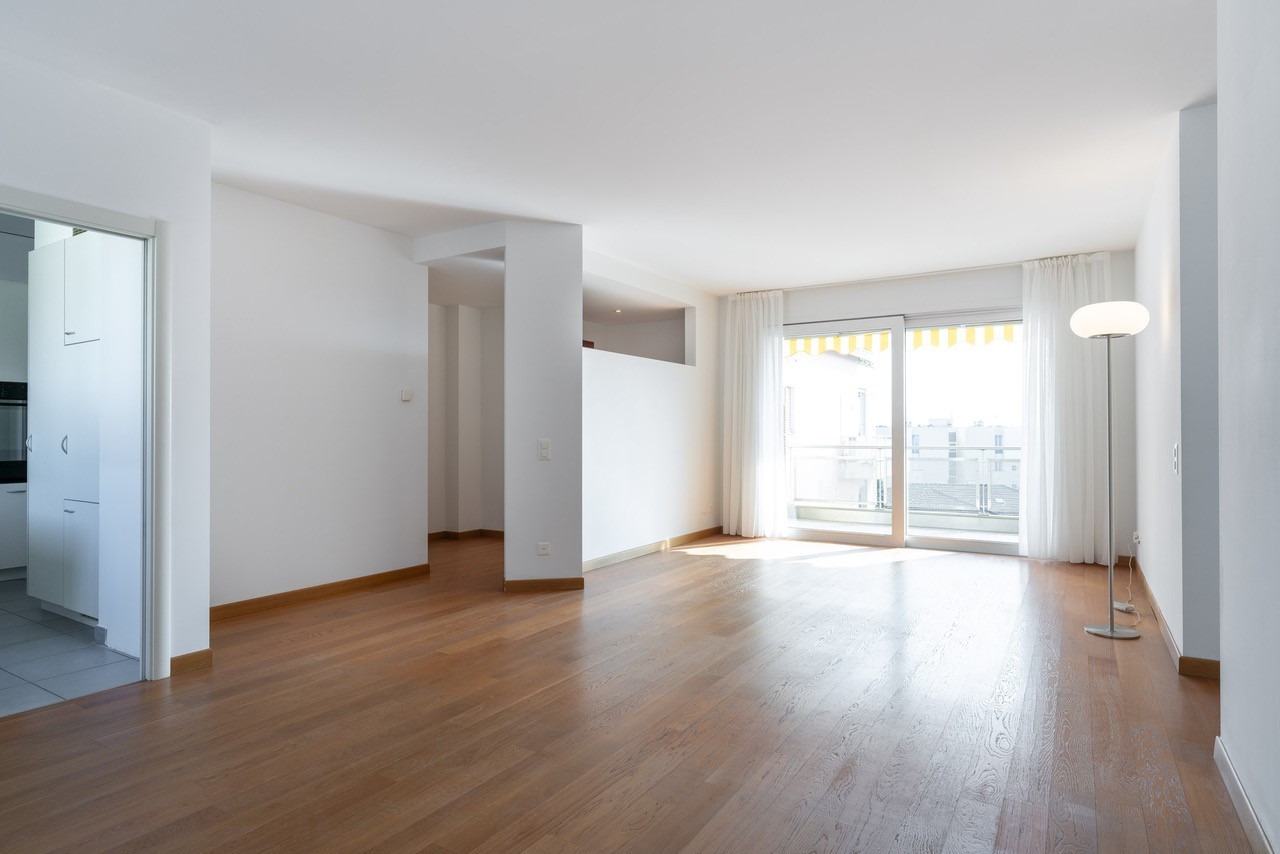 Heller Wohnraum mit Parkett und Balkonfenster