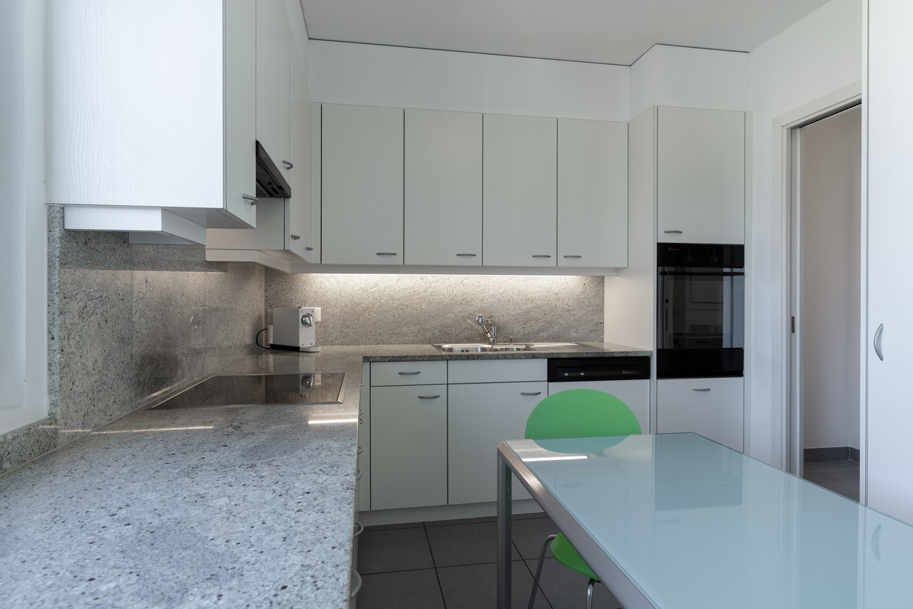 Moderne Küche mit Glas-Esstisch