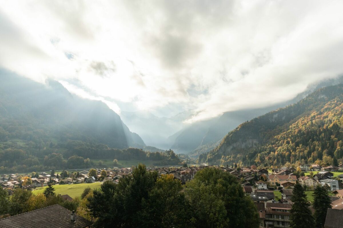 Panoramablick auf ein alpines Tal mit Siedlung