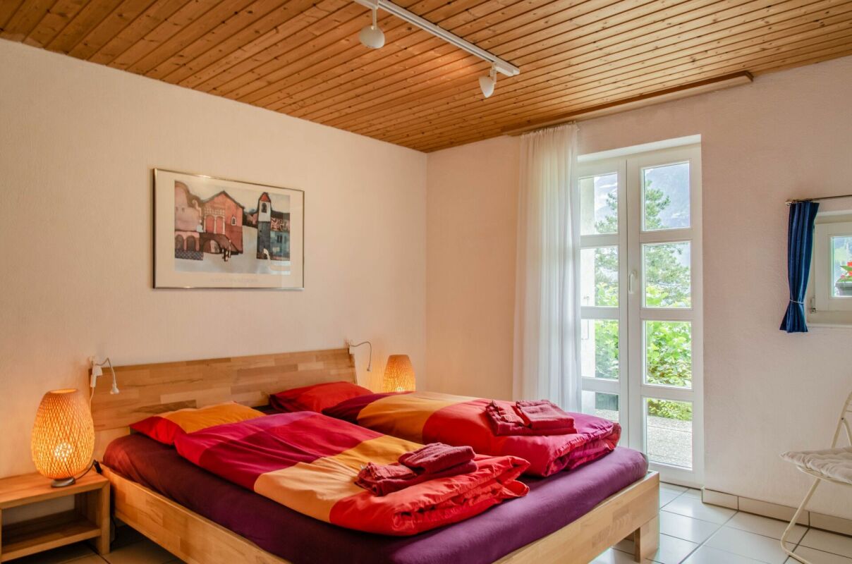 Schlafzimmer mit Doppelbett und Holzdecke