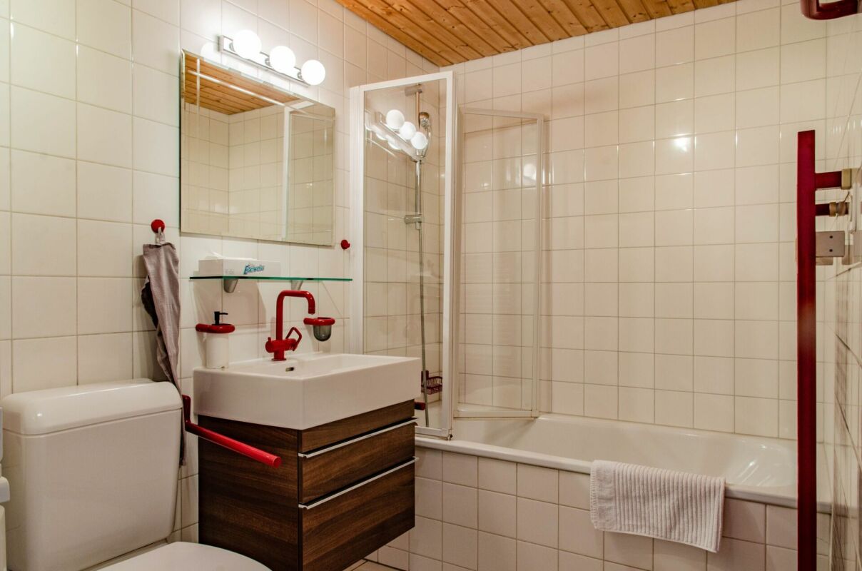Modernes Bad mit Badewanne und roten Akzenten