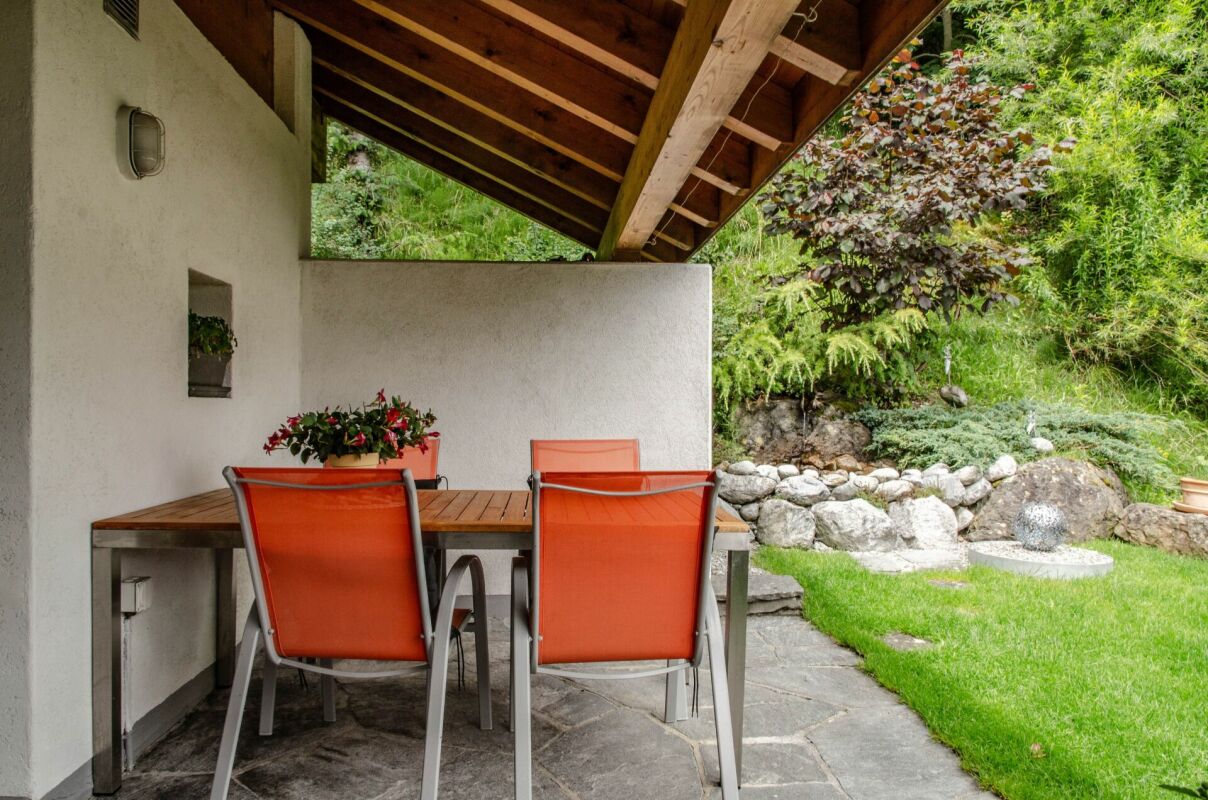 Überdachte Terrasse mit Gartenblick