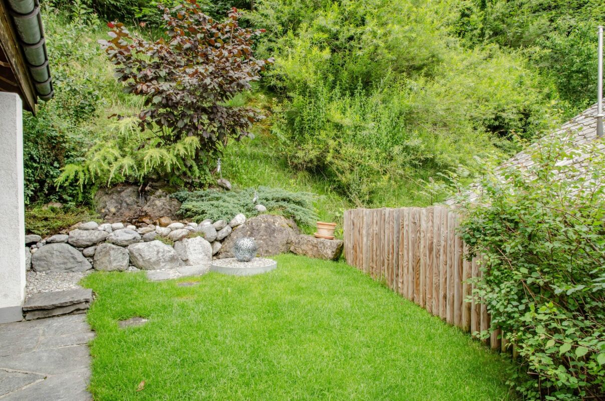 Grüner Garten mit Natursteinmauer