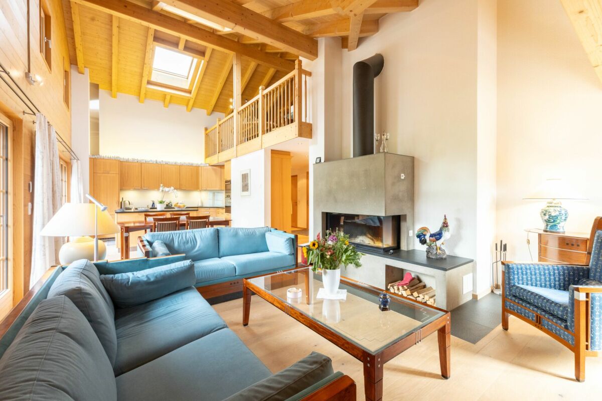 Offener Wohnbereich mit Kamin und Galerie