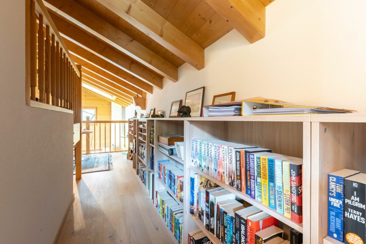 Heller Dachgeschossflur mit Holzdecke und Bücherregalen