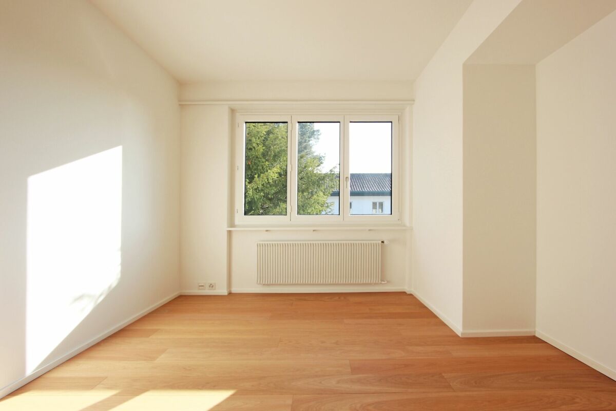 Leerer heller Raum mit Fenster und Heizkörper