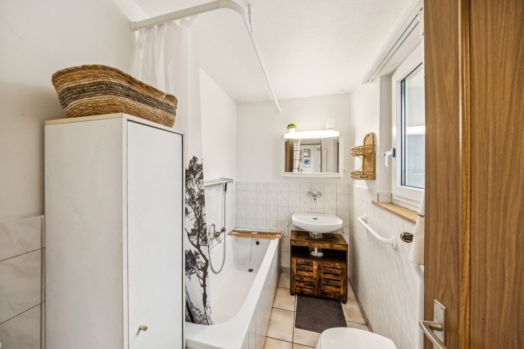 Kleines Badezimmer mit Badewanne und Waschbecken