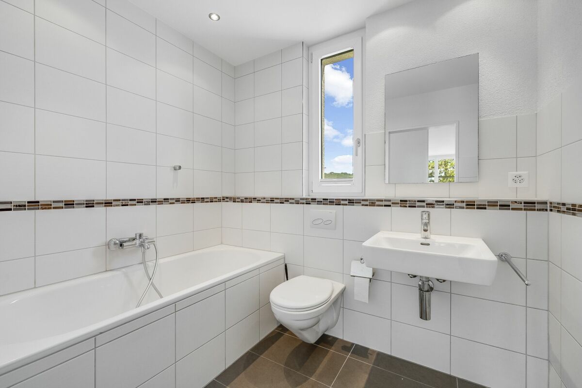 Helles Badezimmer mit Badewanne, WC und Waschbecken