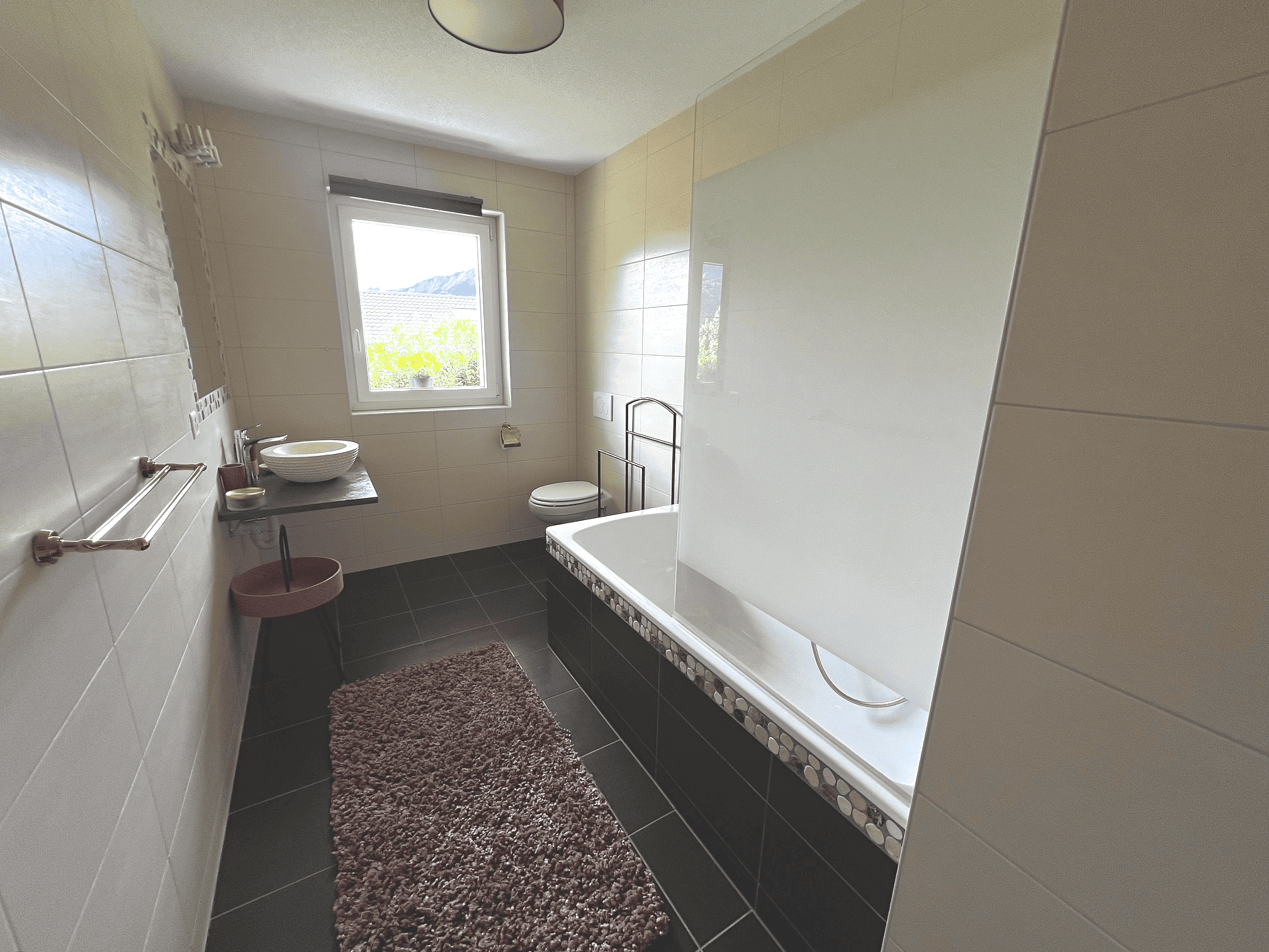 Modernes Badezimmer mit Badewanne und Fensterblick