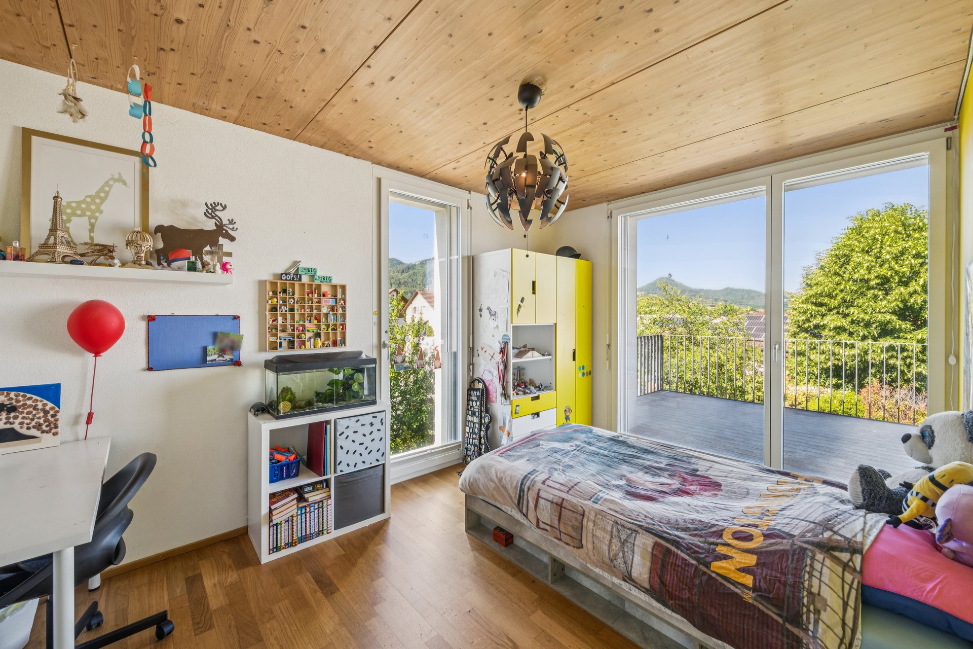 Helles Kinderzimmer mit Balkon und Bergblick