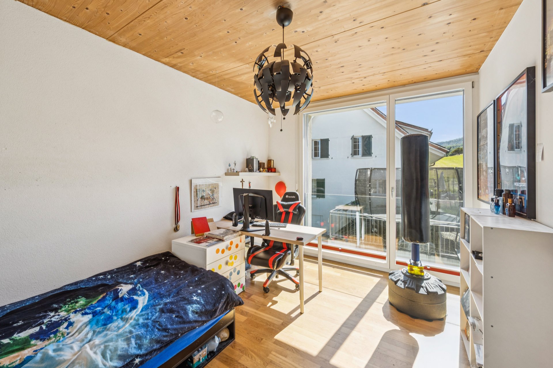 Helles Schlafzimmer mit Arbeitsplatz und Balkonzugang