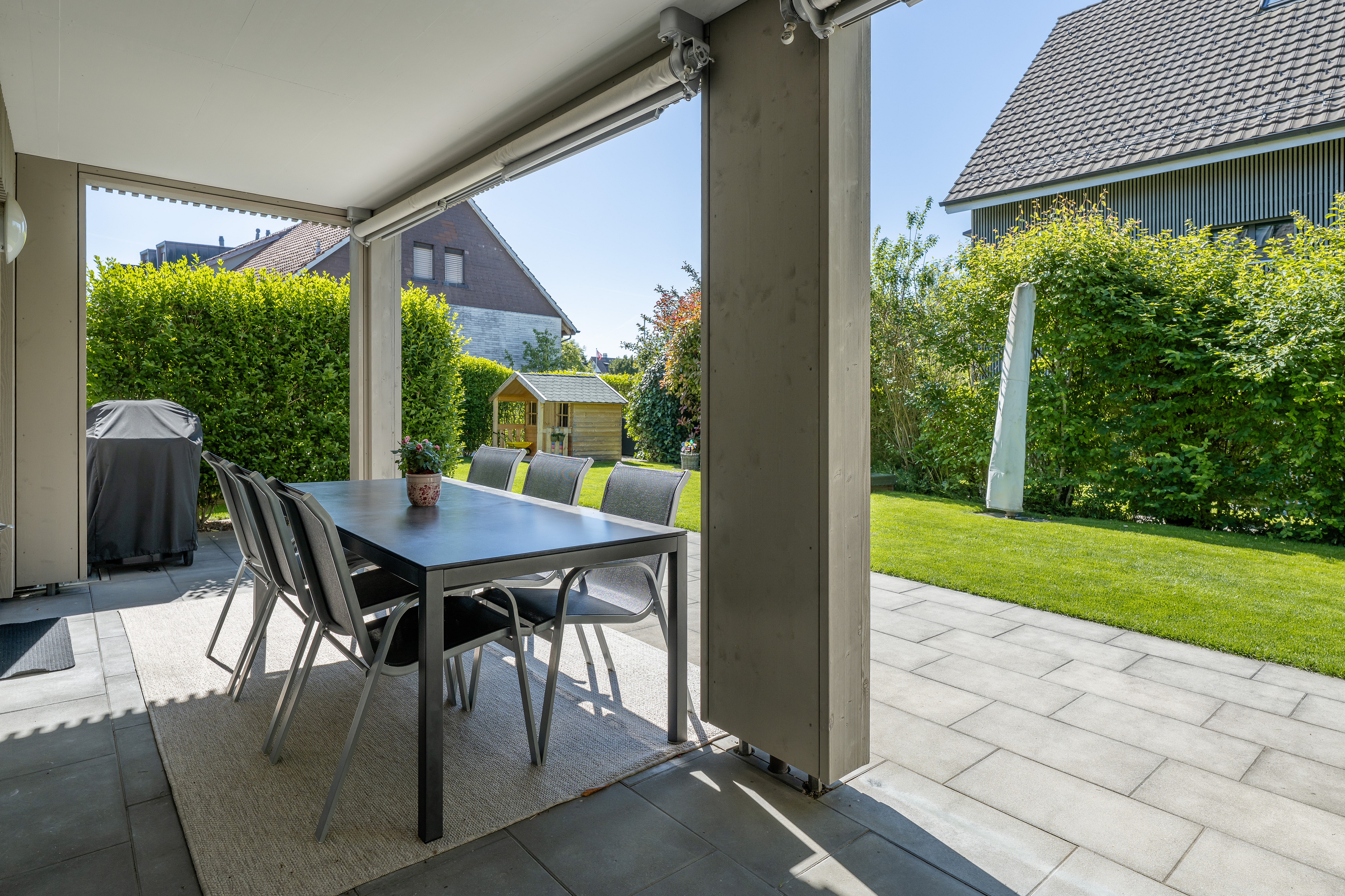 Überdachte Terrasse mit Gartenblick