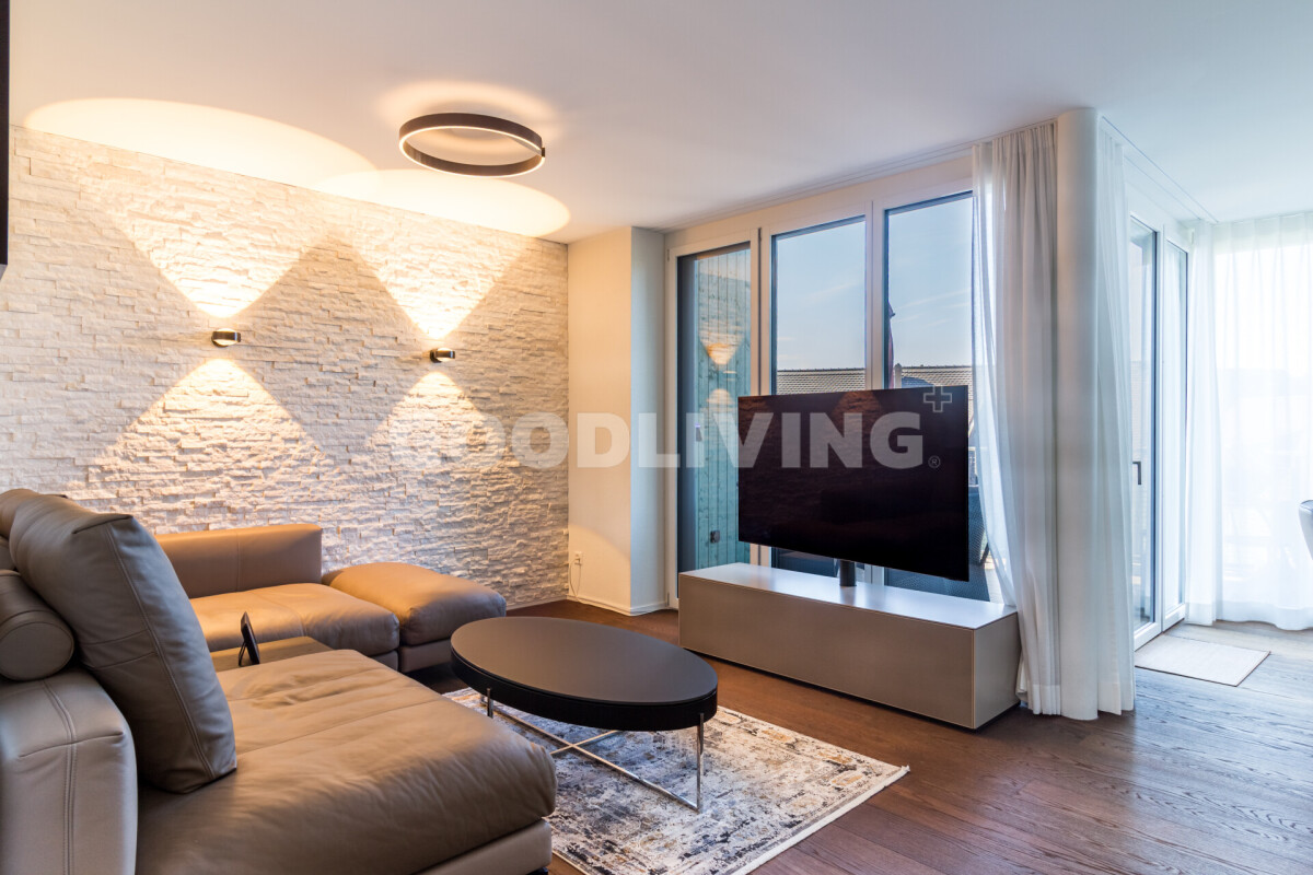 Wohnzimmer mit bodentiefen Fenstern und Steinwand